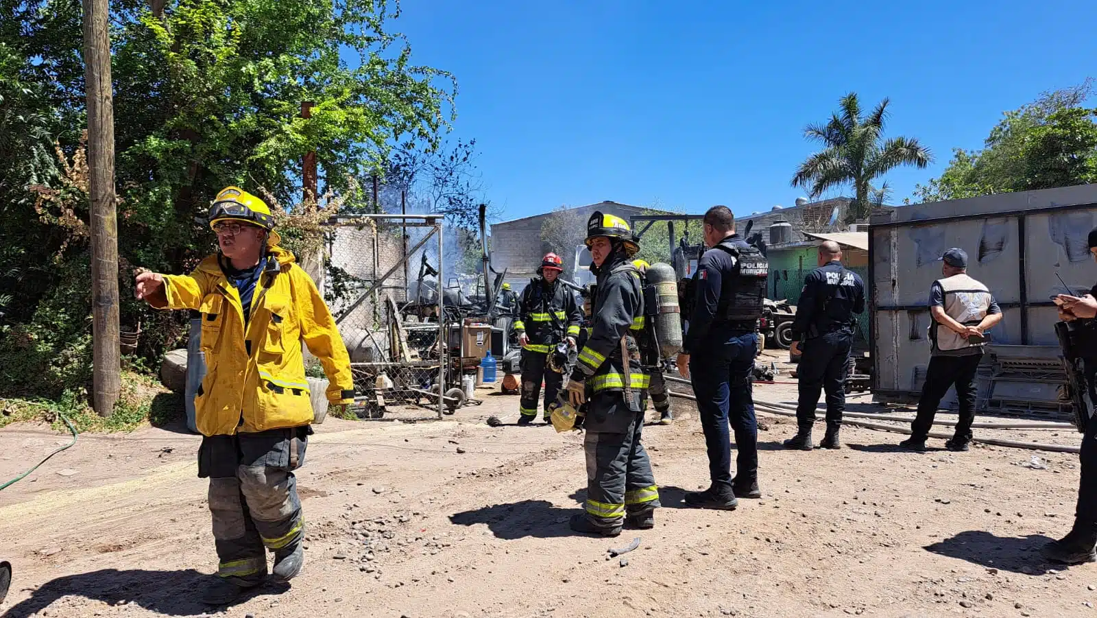 Elementos de bomberos y policía municipal en el lugar donde se incendiaron 3 tractocamiones en Culiacán