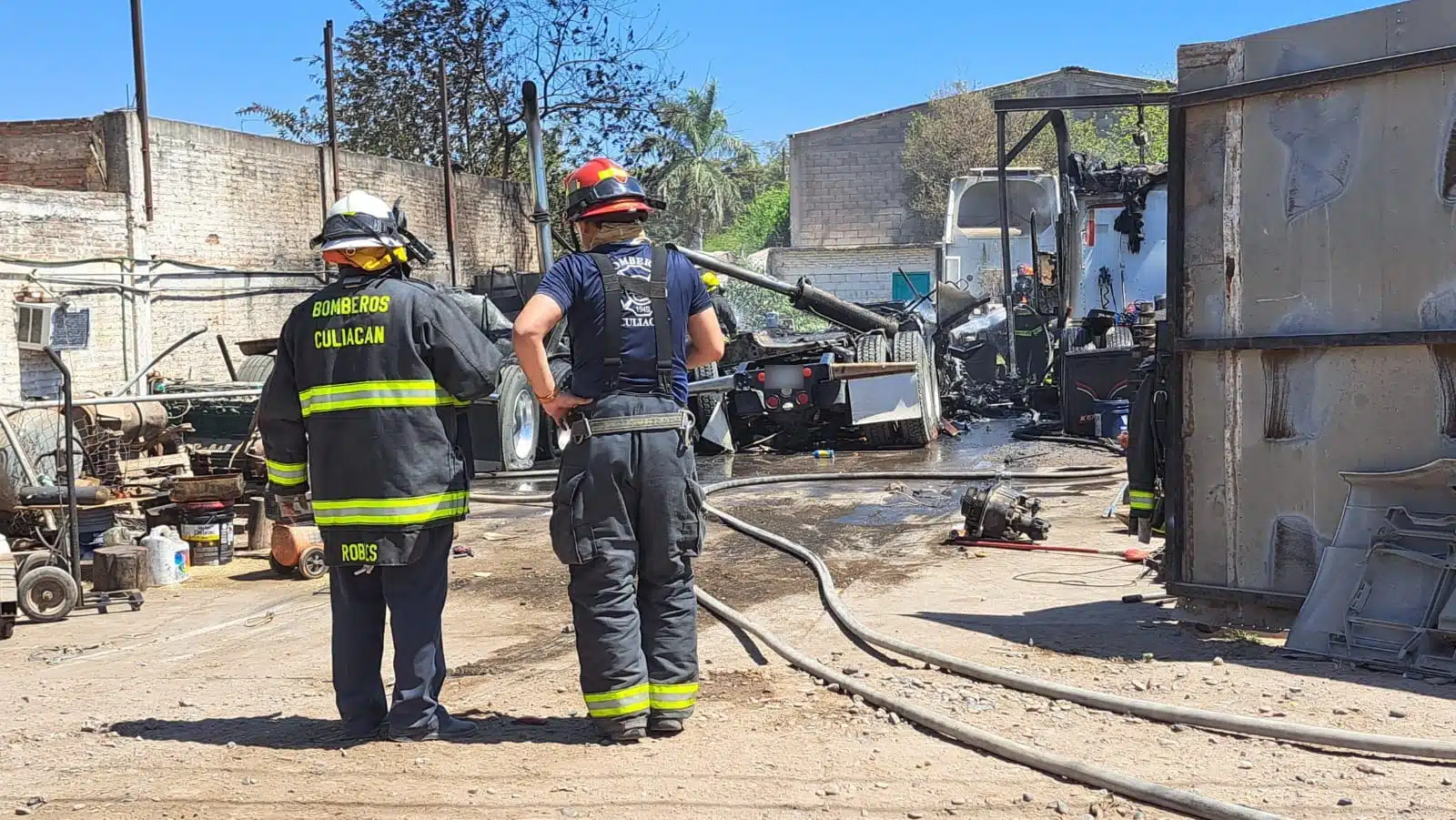 Elementos de bomberos en el lugar donde se incendiaron tres tractocamiones en Culiacán
