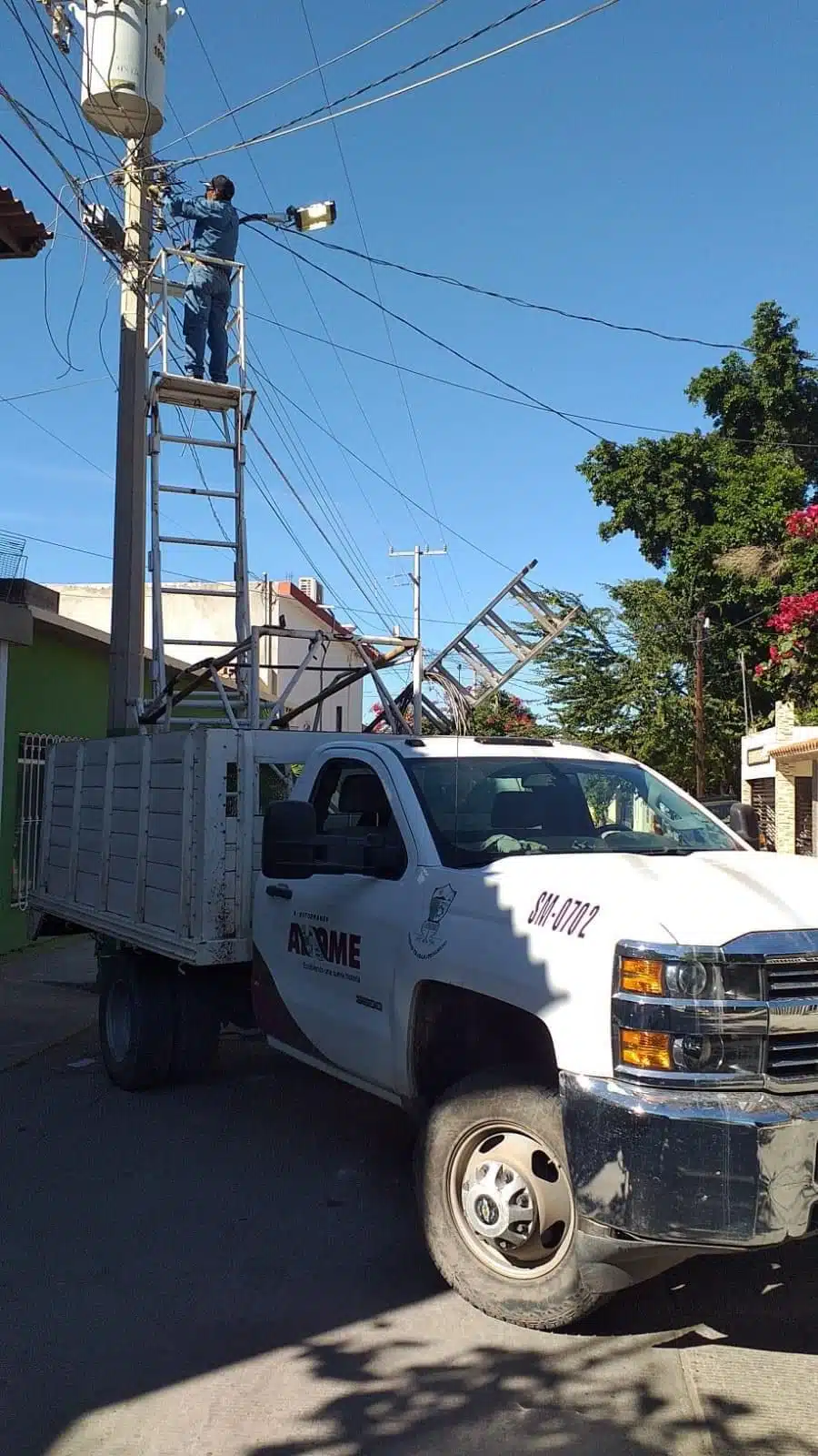 Un trabajador del ayuntamiento de Ahome poniendo lámparas led