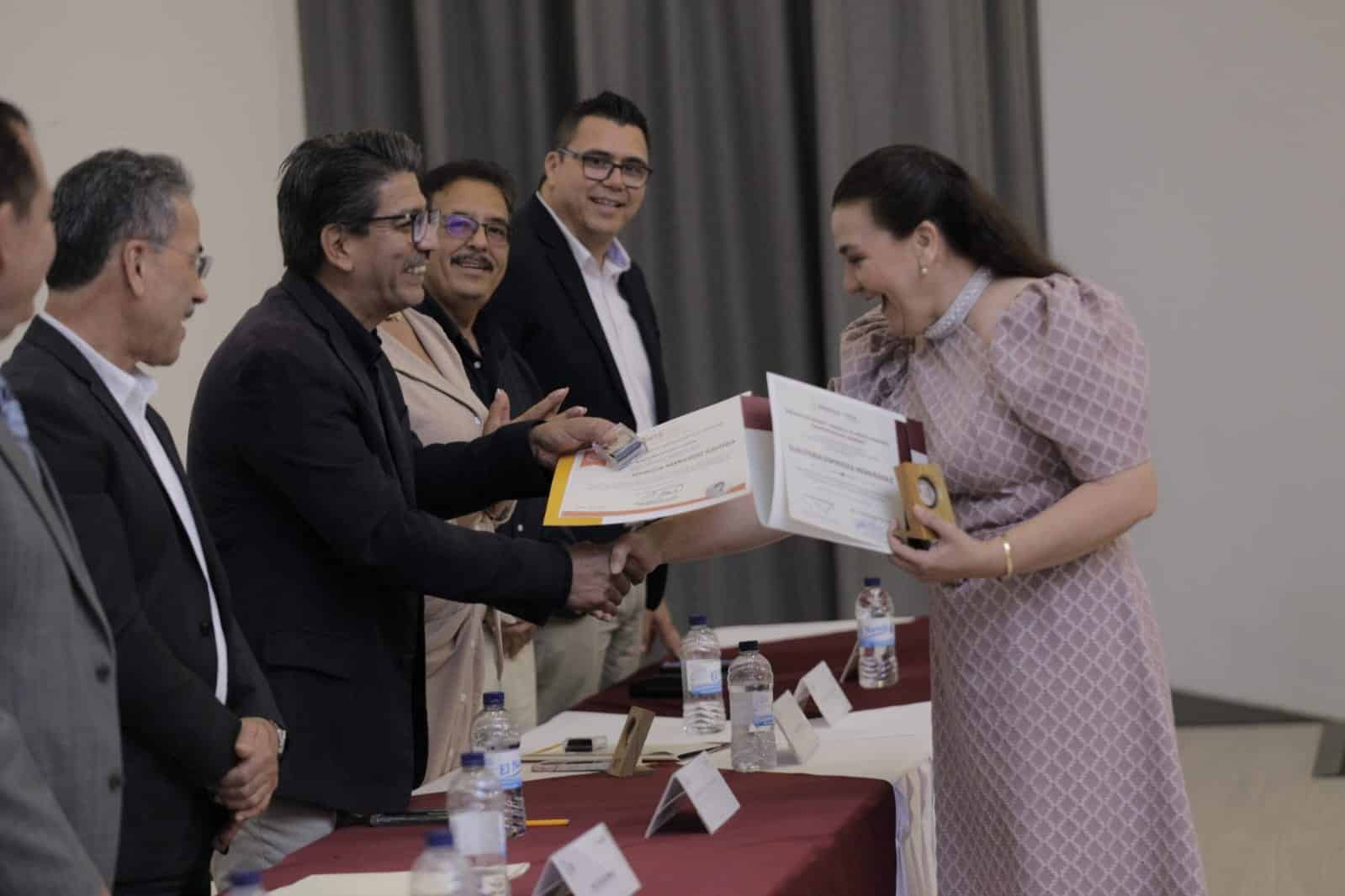 Martín Ahumada Quintero, presidente municipal de Guasave, haciendo entrega de un reconocimiento a una maestra por sus 28 años de servicio