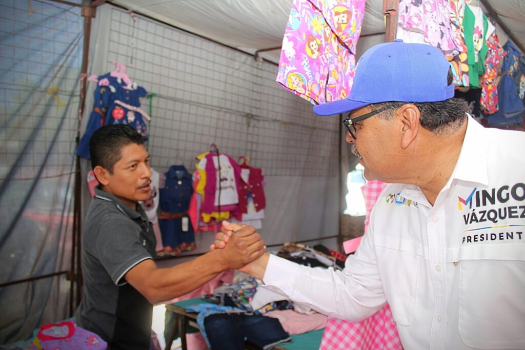 “Mingo” Vázquez estrechando la mano con un vendedor de ropa