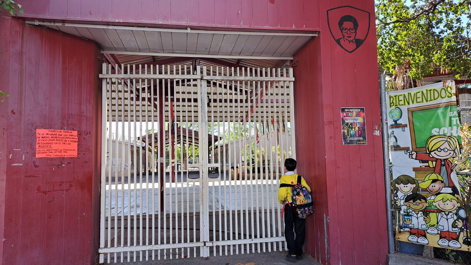 Estudiante parado frente a la entrada de la escuela