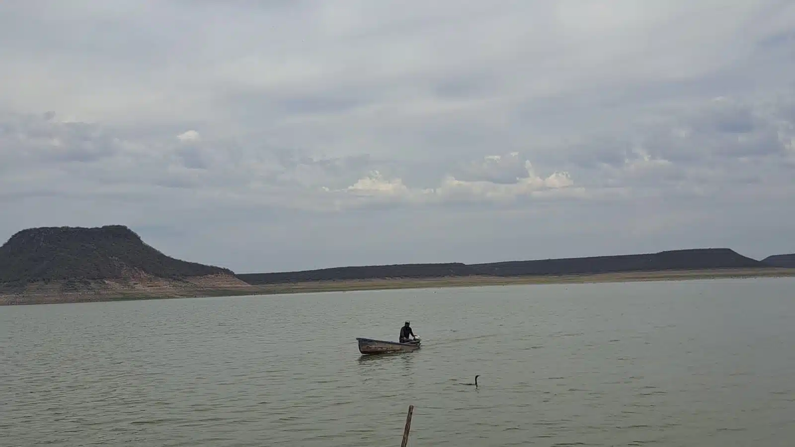 Una persona pescando en la Presa Miguel Hidalgo y Costilla en El Fuerte