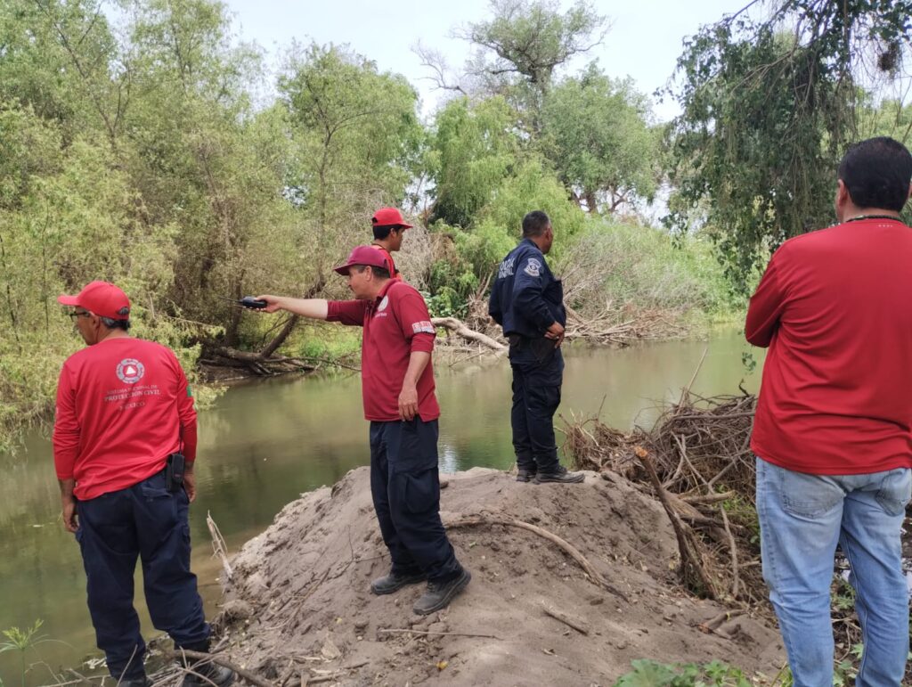 5 personas, 4 pertenecen a Protección Civil y la otra a la Policía Municipal de Guasave en el río Sinaloa