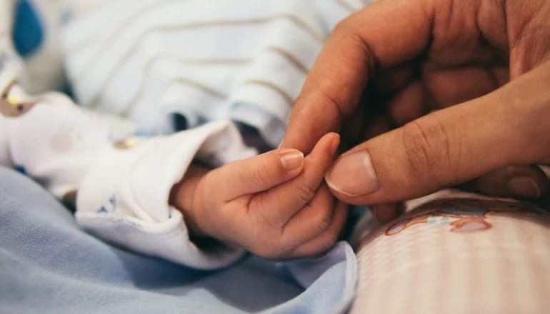 Mano de niño y de persona adulta