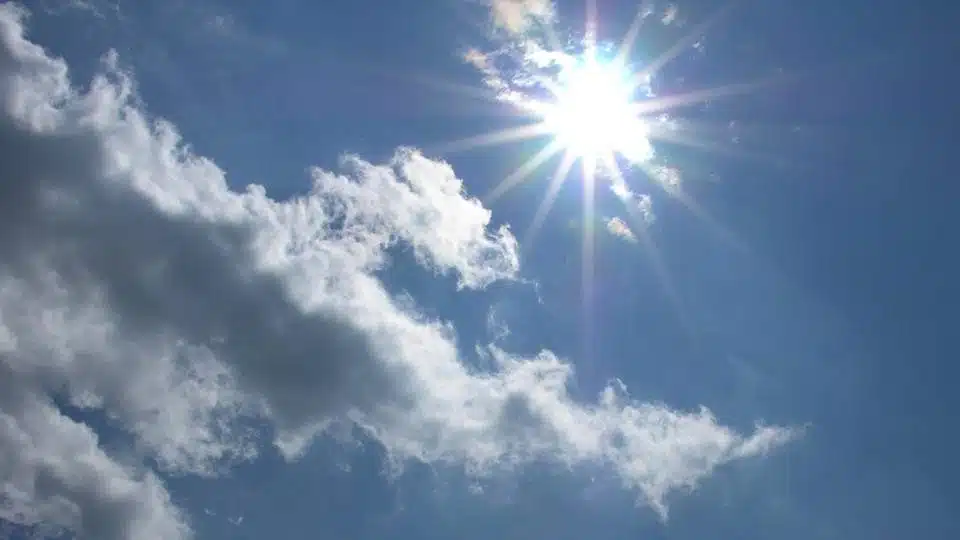 Cielo con sol en lo alto y pocas nubes