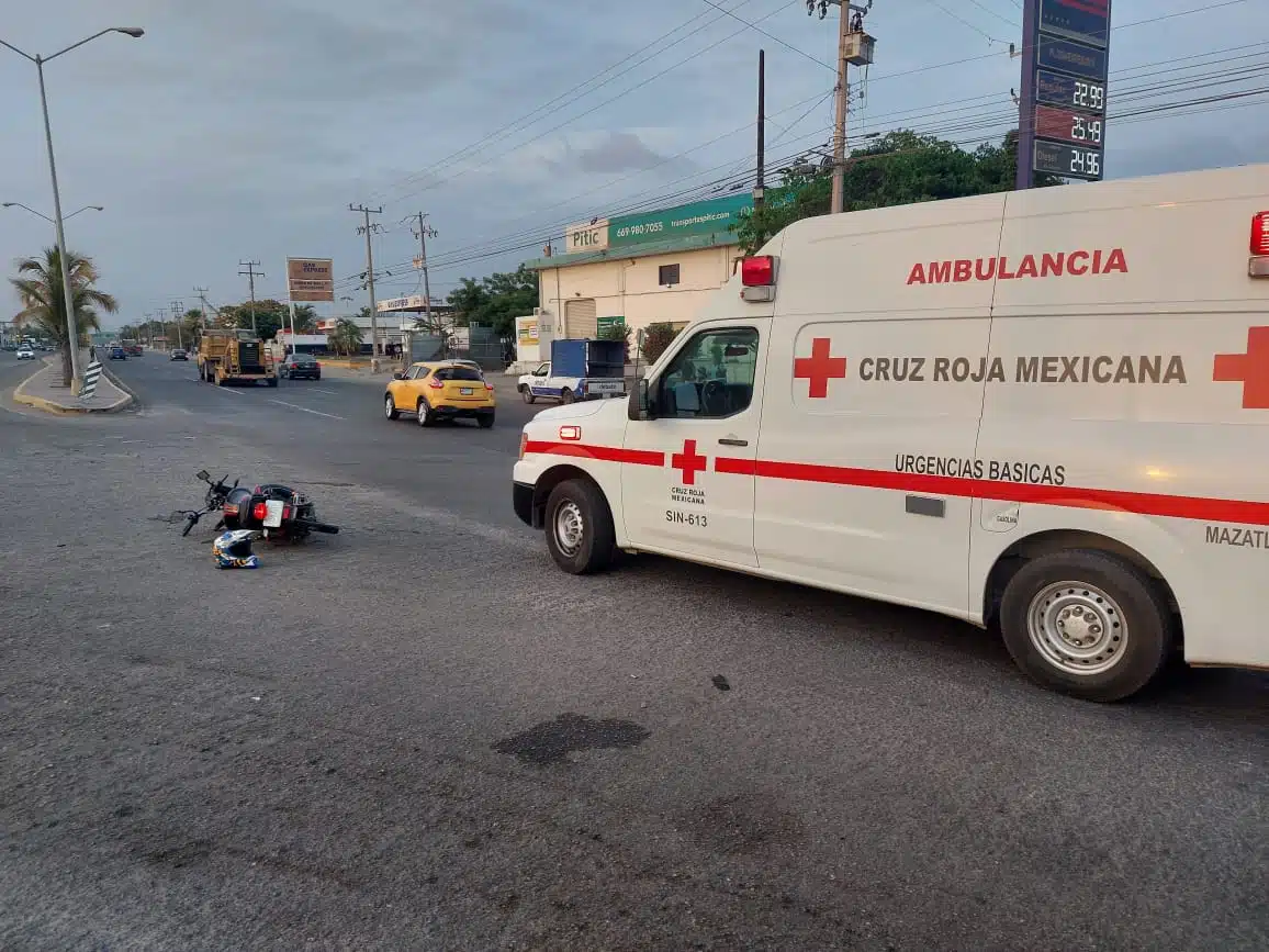 Ambulancia de la Cruz Roja junto a una motocicleta tirada en la calle