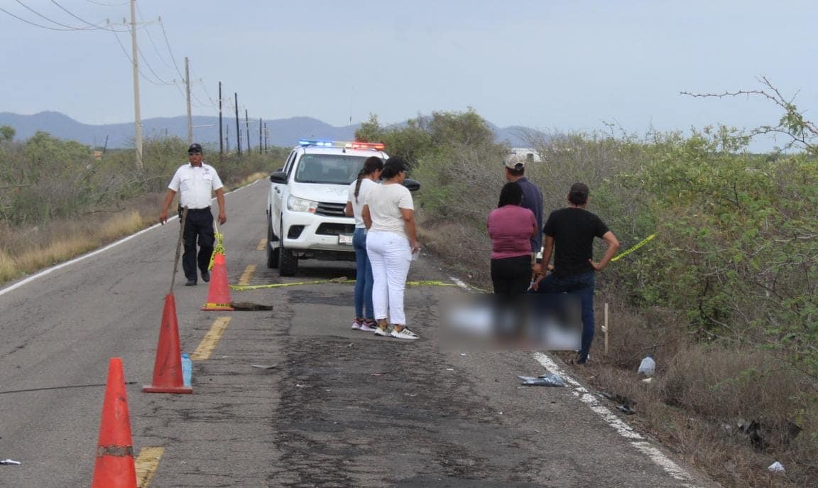 Personas junto al cuerpo de Ernesto, quien falleció después de chocar contra un taxi cuando viajaba en su motocicleta en la carretera Agua Verde-Caimanero, Rosario