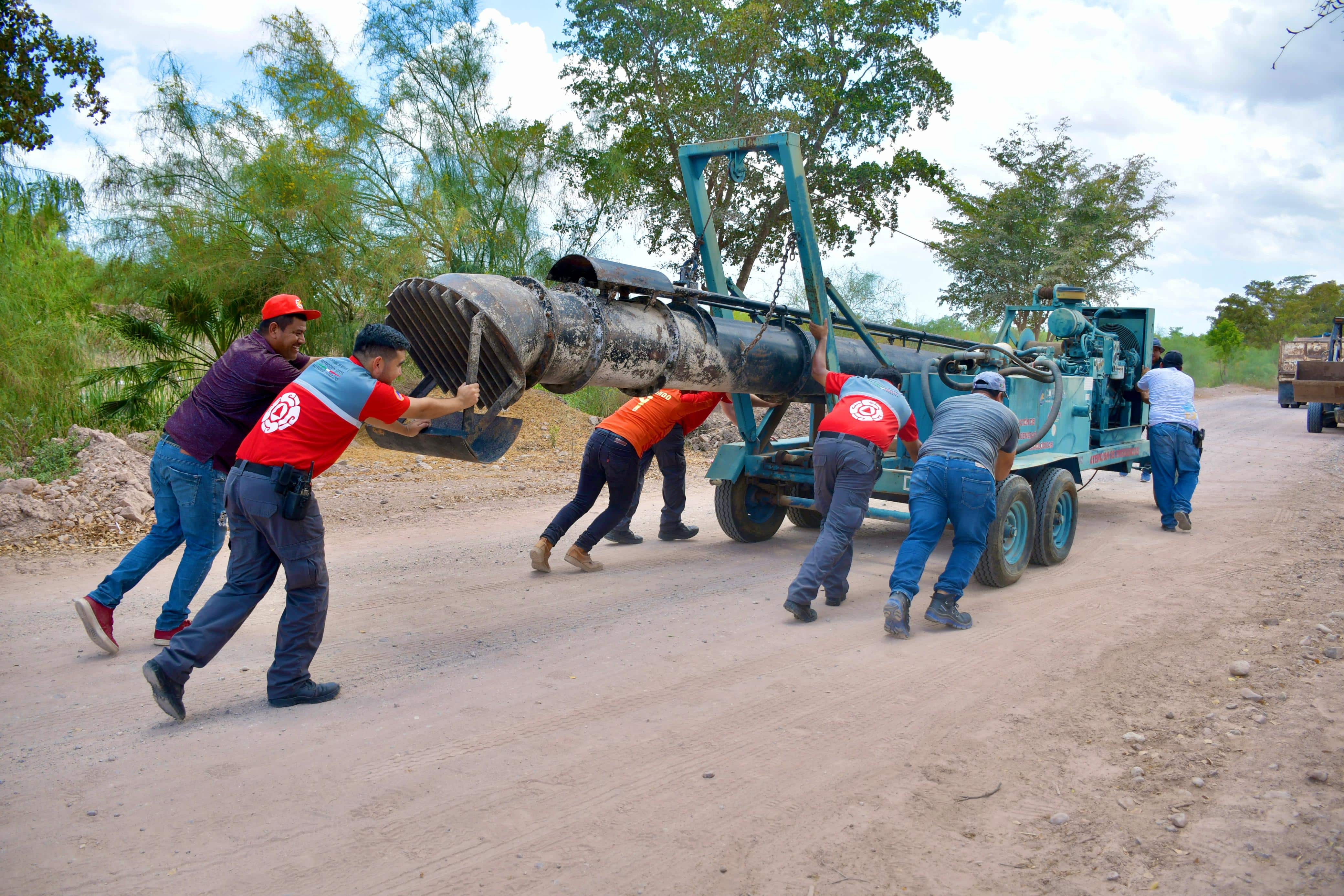 Elementos de Protección Civil instalando bombas de succión en la colonia Las Garzas en Guamúchil