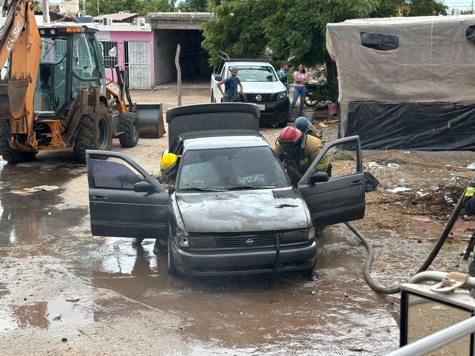 Carro incendiado del motor y elementos de bomberos de Elota en el lugar