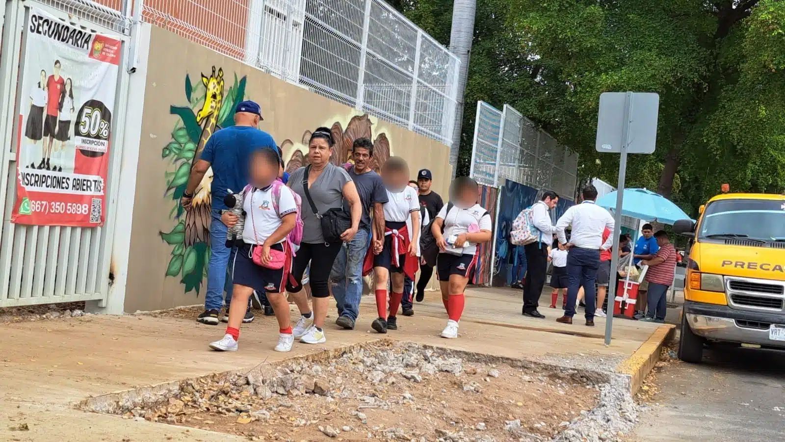 Niños y padres de familia saliendo de una escuela en Culiacán