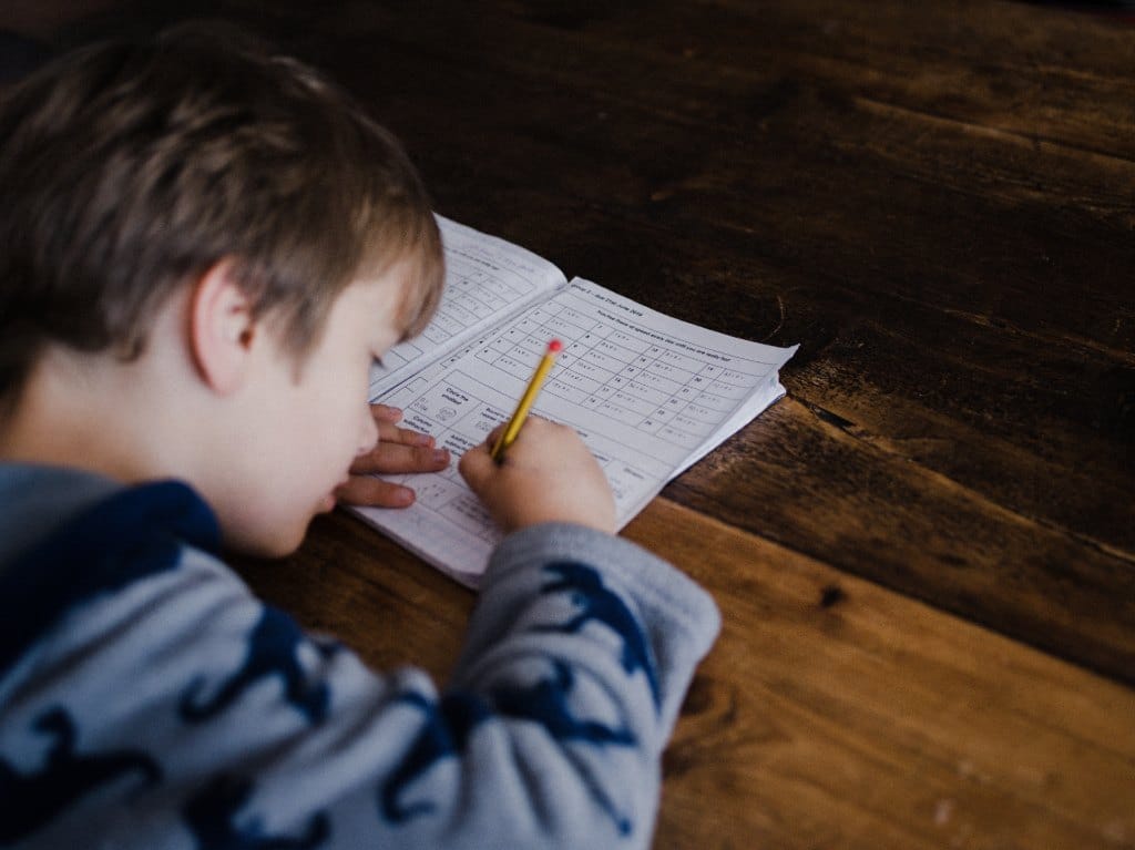 Niño estudiante realizando una actividad con su material de trabajo