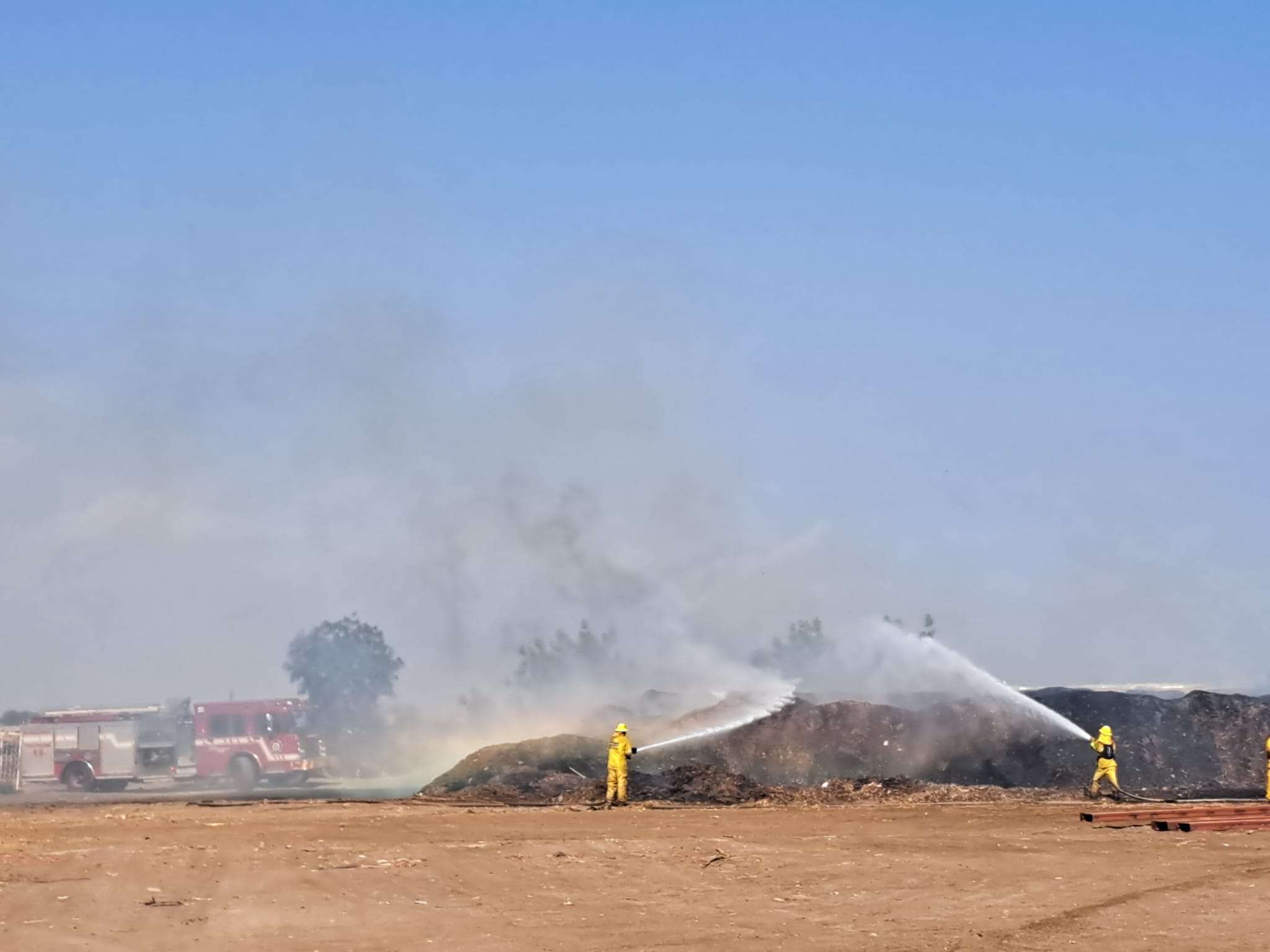 Bomberos combatiendo el incendio en el campo agrícola.