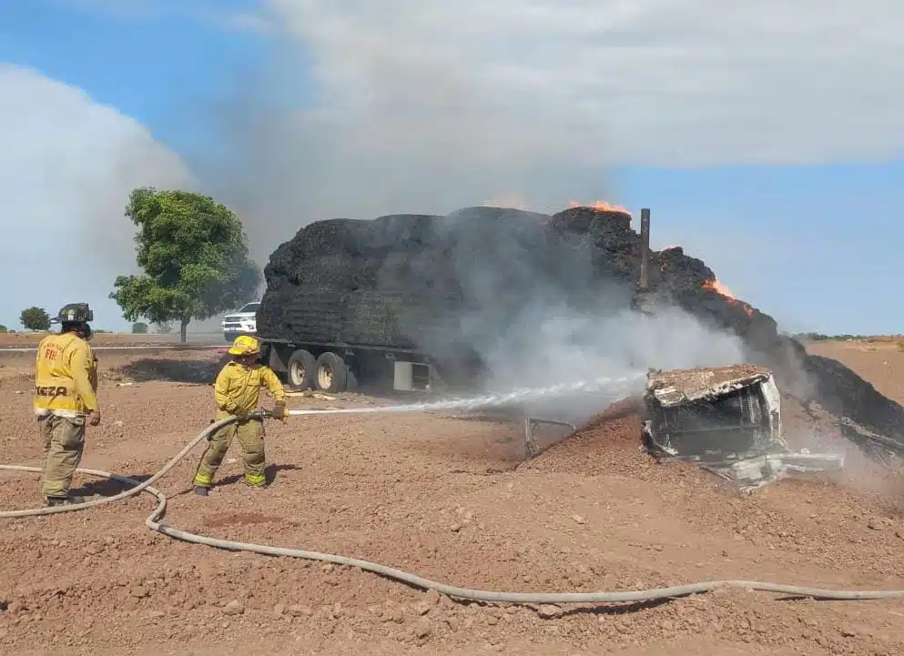 Bomberos extinguiendo el fuego de la unidad que transportaba pacas