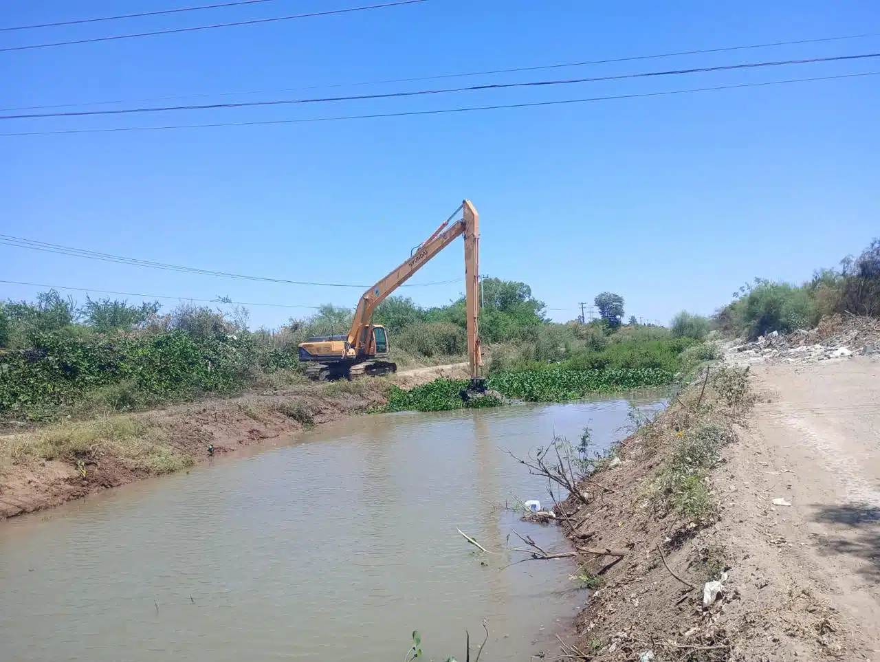 Una retroexcavadora limpiando en el dren Mochicahui en Los Mochis