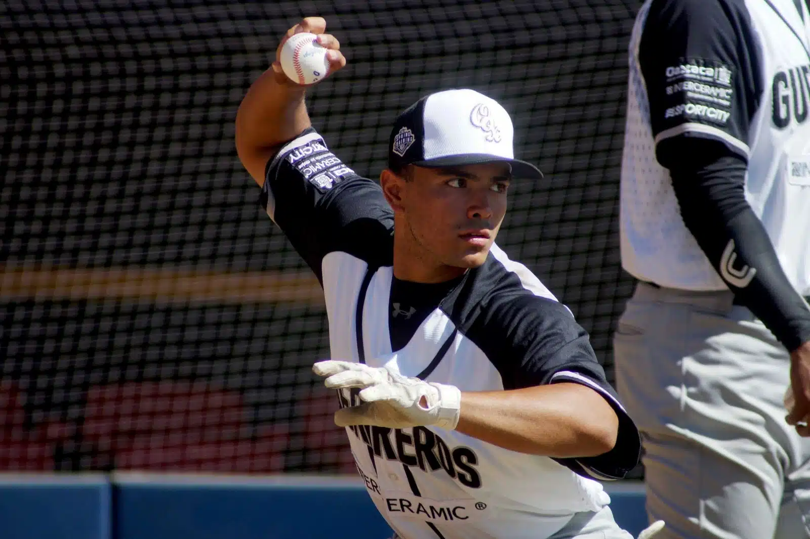 Miguel Ojeda Jr. con uniforme de beisbol y una pelota