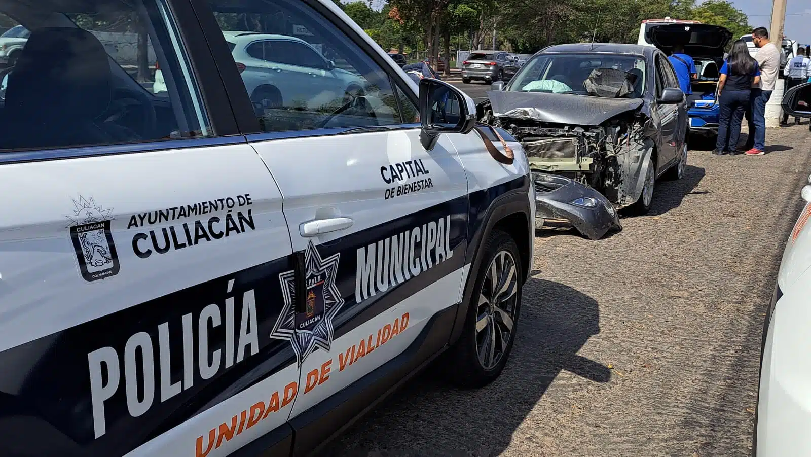 Patrulla de la Policía Municipal junto a automóvil destrozado por choque múltiple, en Culiacán