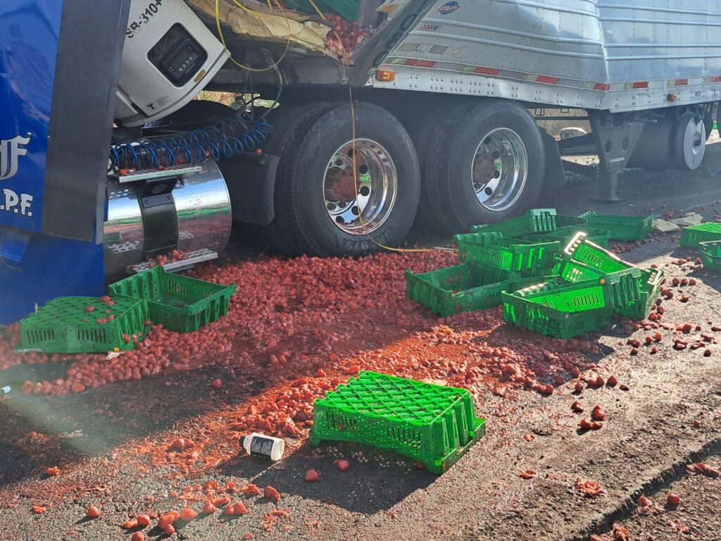 Cajas de fresas sobre carretera tras accidente de tráiler