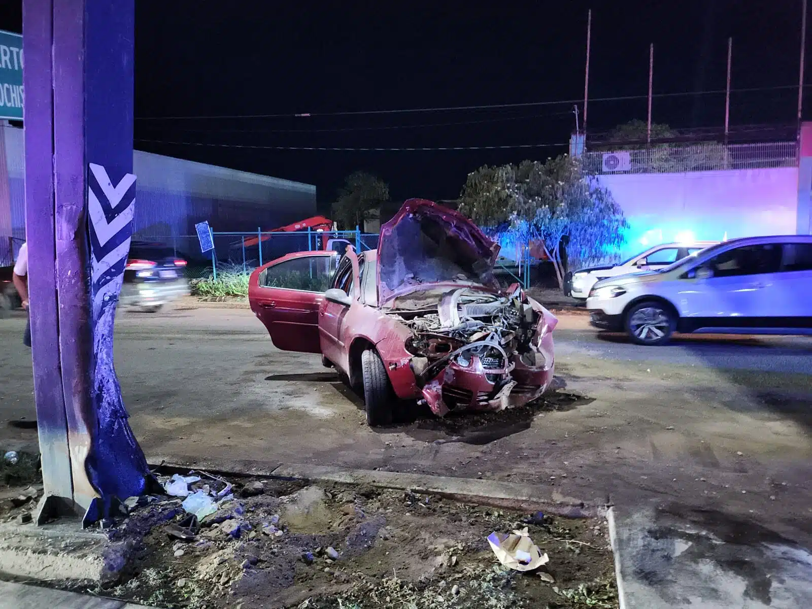 Vehículo Dodge Neón rojo con severos daños en la parte delantera