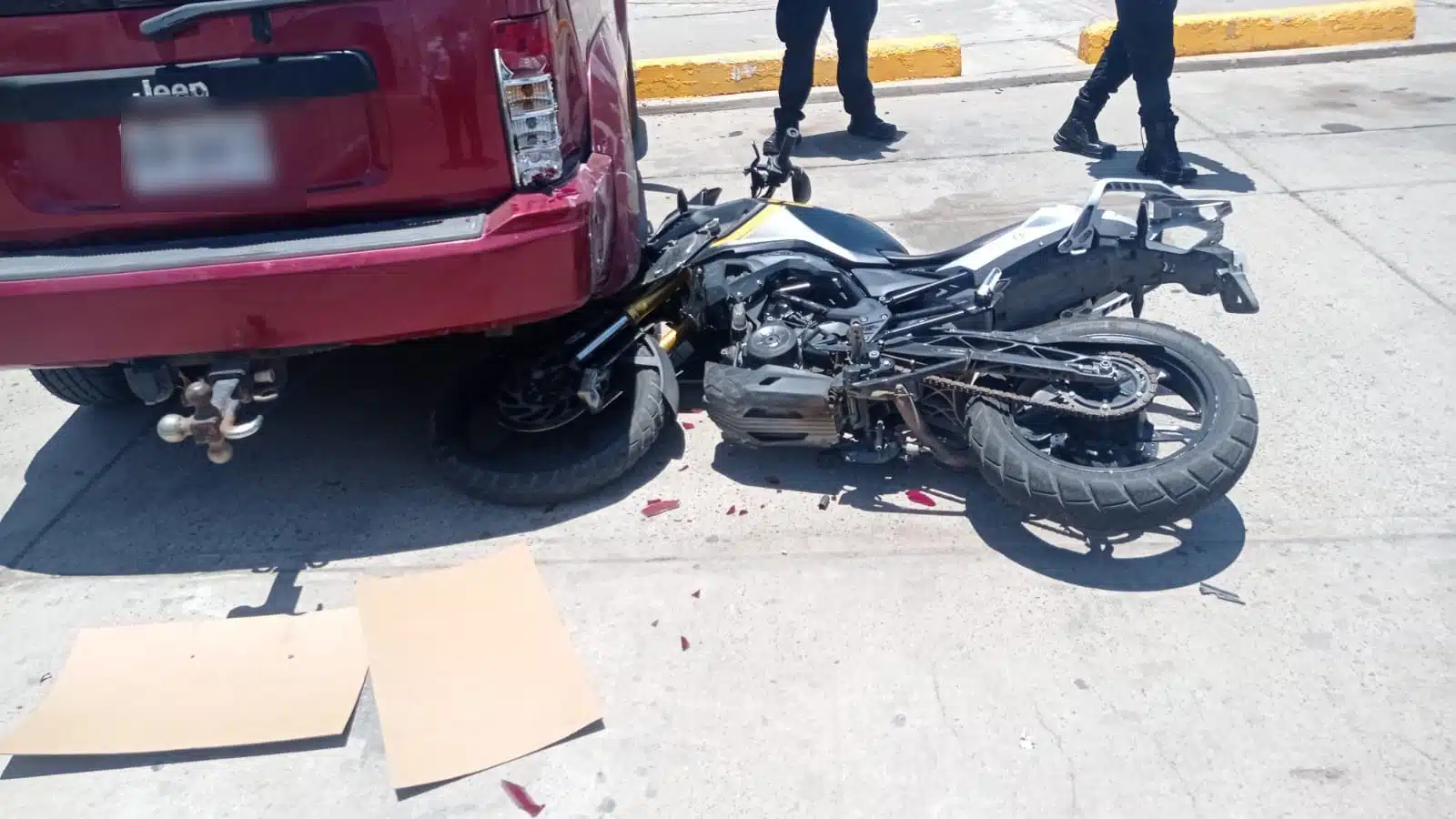 Motocicleta tirada junto a una camioneta roja