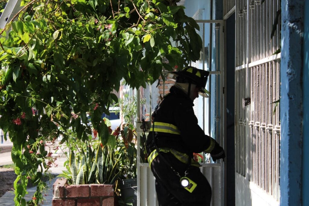 Elemento de bombero entrando en la casa que se incendió en la colonia 20 de Noviembre en Mazatlán