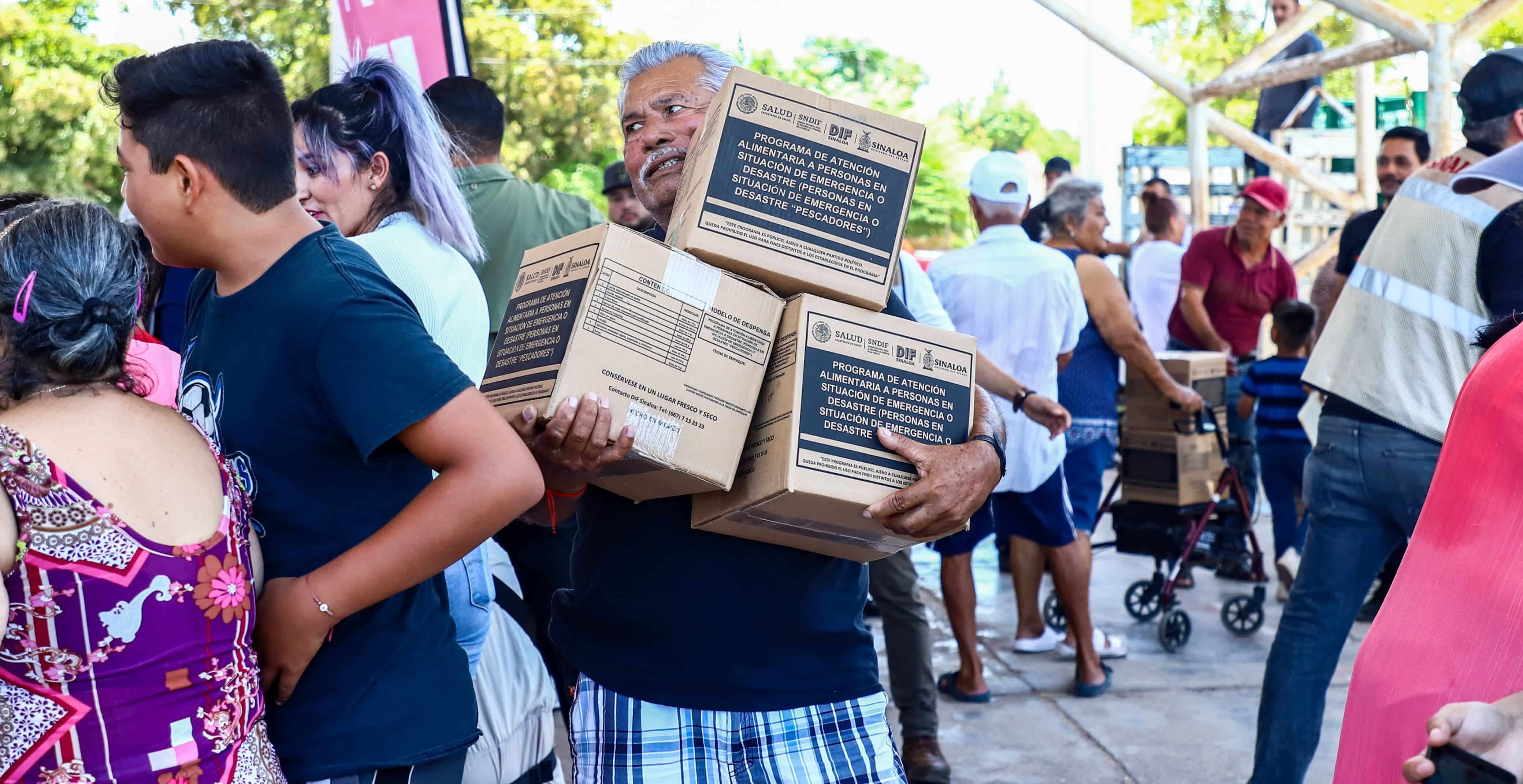 Un hombre recibiendo despensa por parte del Sistema DIF de Sinaloa en Altata, Navolato