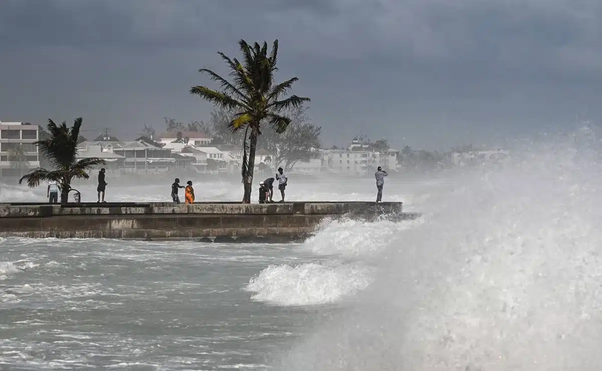 Personas observan las marejadas ciclónicas desde un puerto