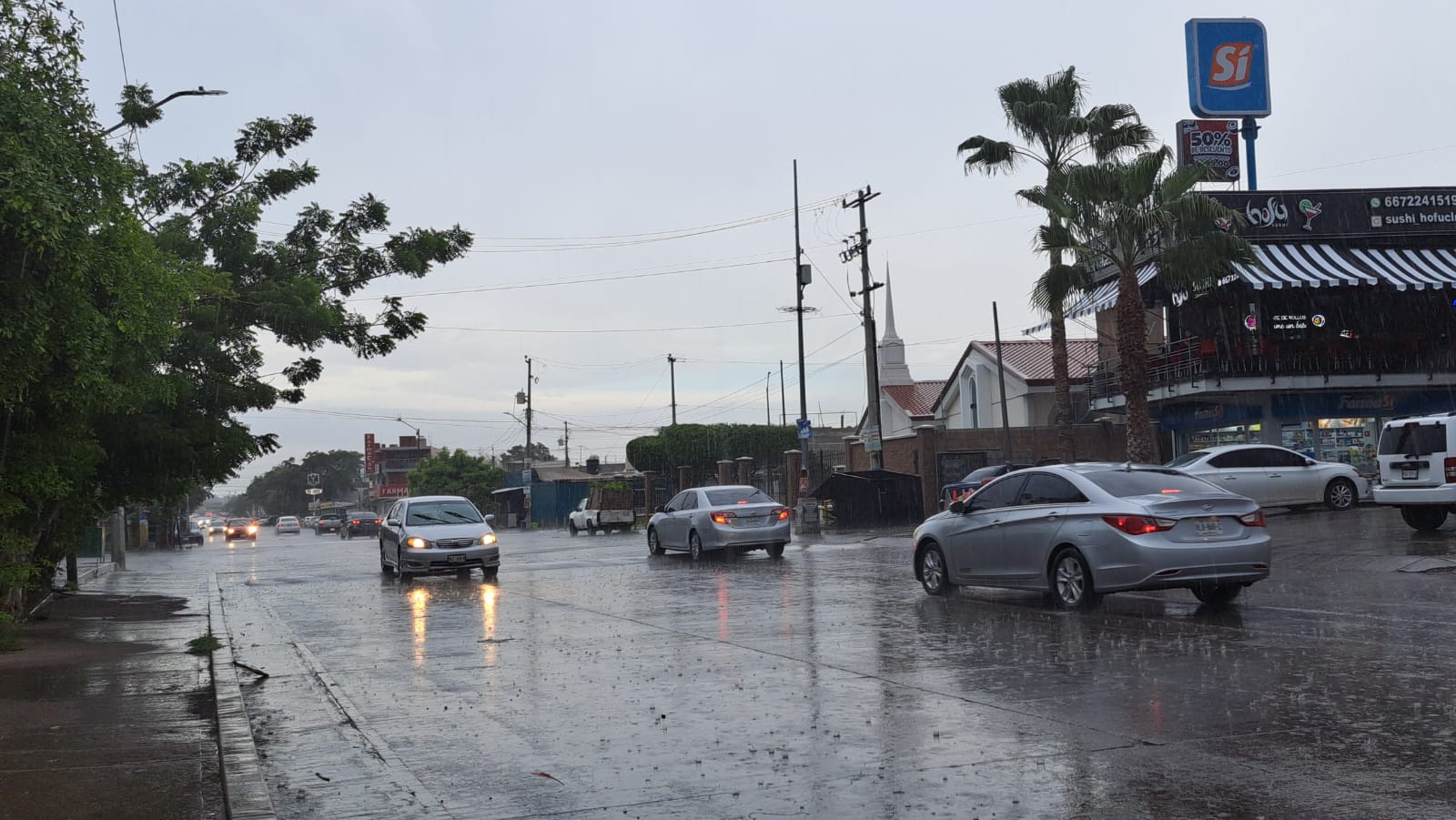 Carros circulando durante la lluvia esta tarde de miércoles