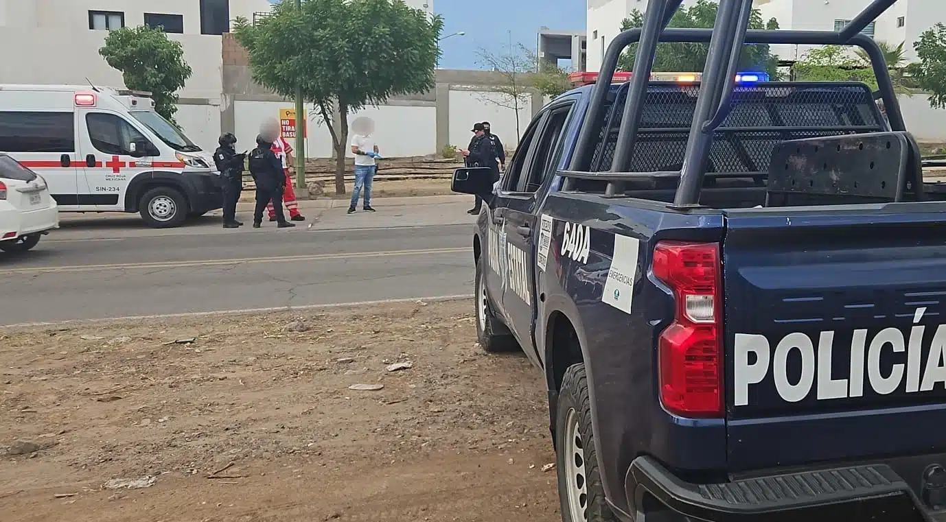 Elementos de la Policía Municipal de Culiacán y de Cruz Roja esperando a 2 personas que sufrieron lesiones cuando fueron a rematar a hombre en Los Mayos, Sanalona