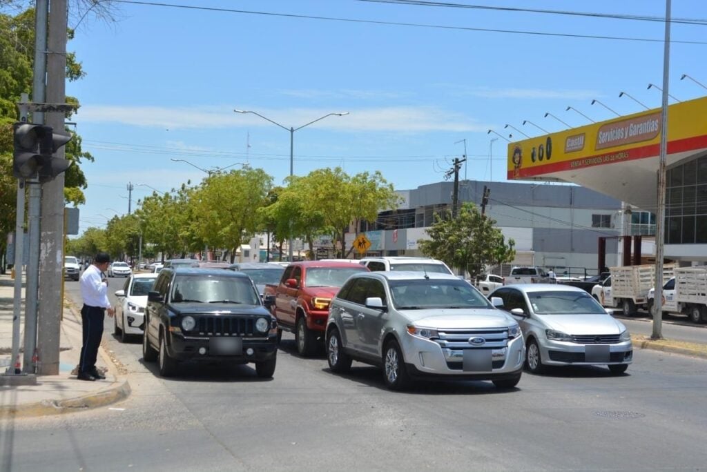 Elemento de la Policía de Tránsito Municipal de Los Mochis en la calle dando el pase a los carros