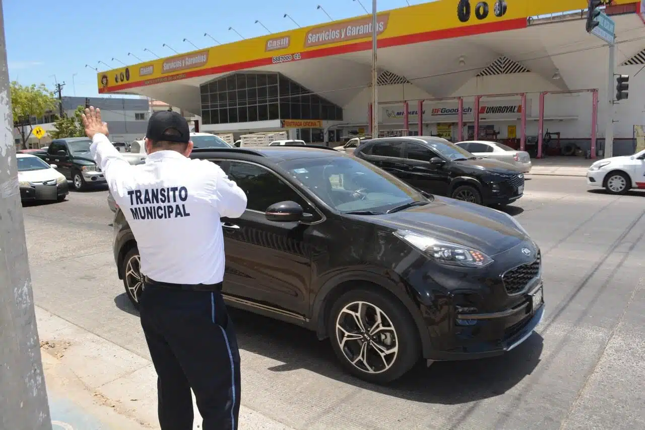 Elemento de la Policía de Tránsito Municipal de Los Mochis en la calle dando el pase a los carros