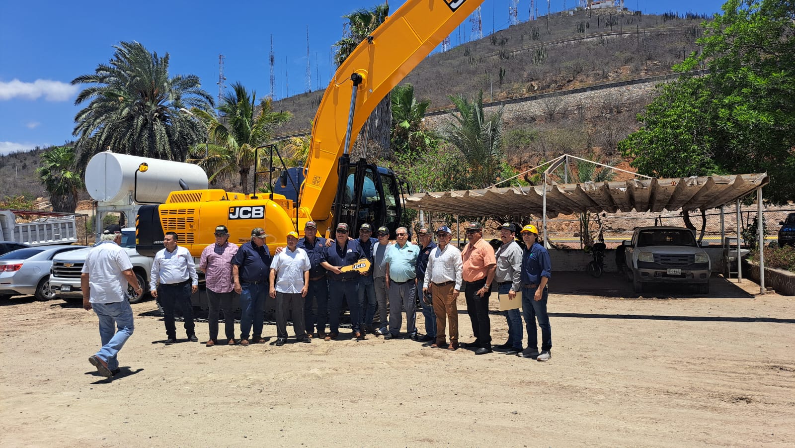 Personas de la Red Mayor del Valle del Fuerte con la excavadora al fondo
