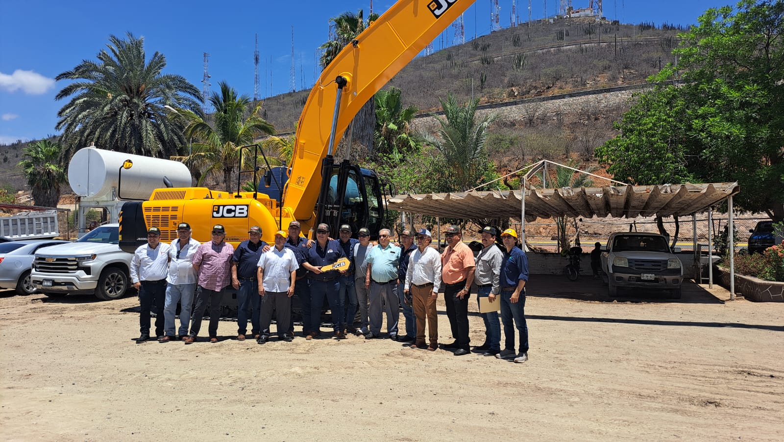 Personas de la Red Mayor del Valle del Fuerte con la excavadora al fondo