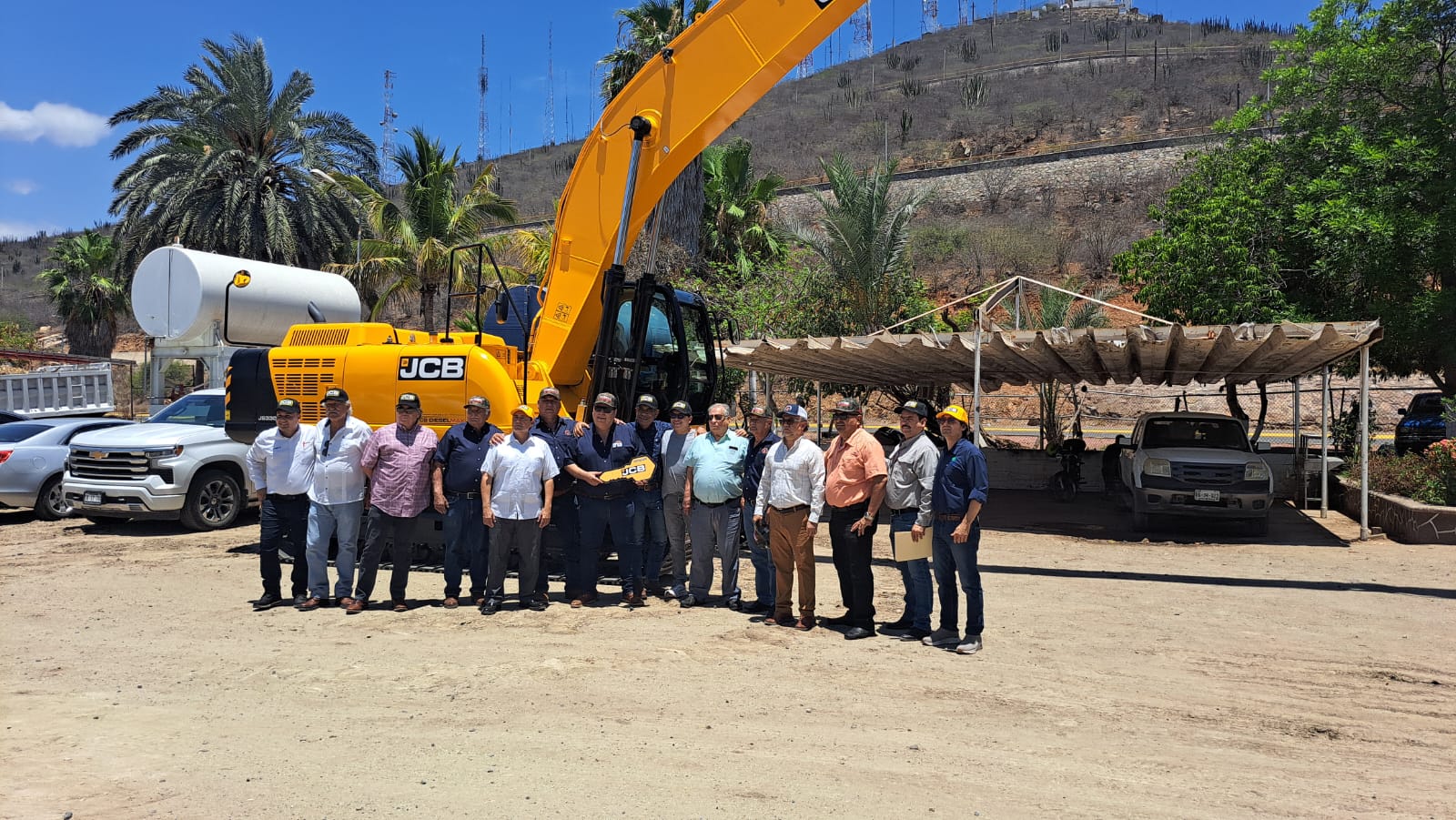 Personas de la Red Mayor del Valle del Fuerte con la excavadora al fondo