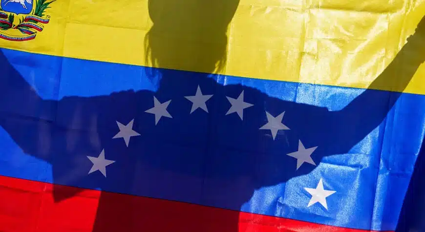 Una persona alza la bandera de Venezuela