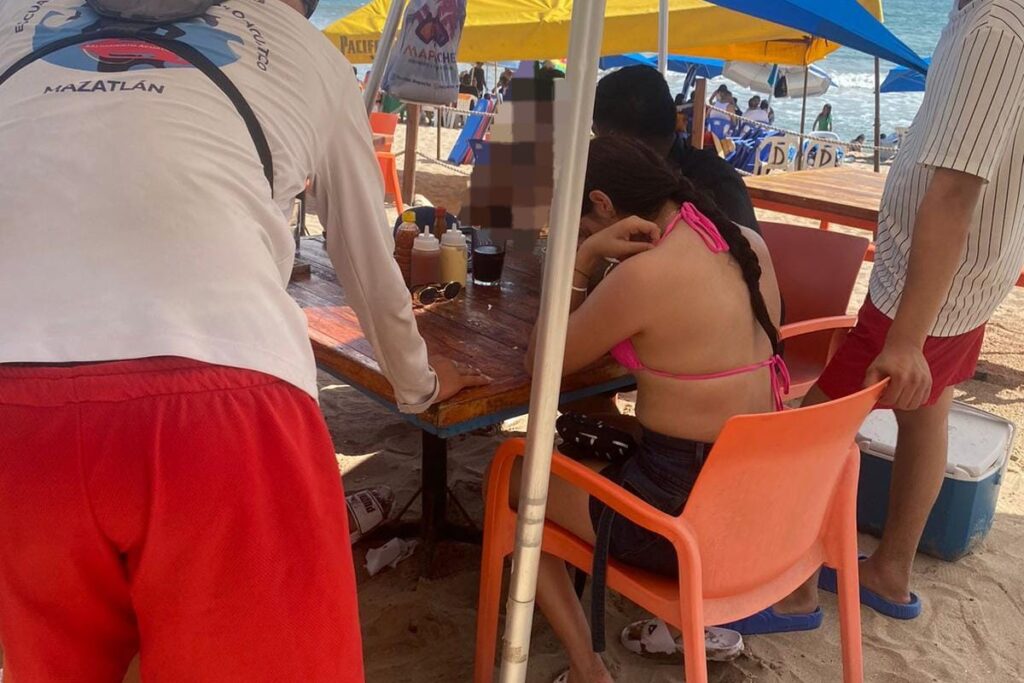 Salvavidas auxiliando a otra mujer en la playa