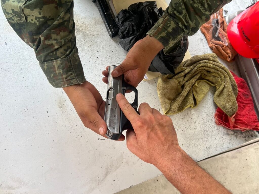 Militar inspeccionando un arma de fuego