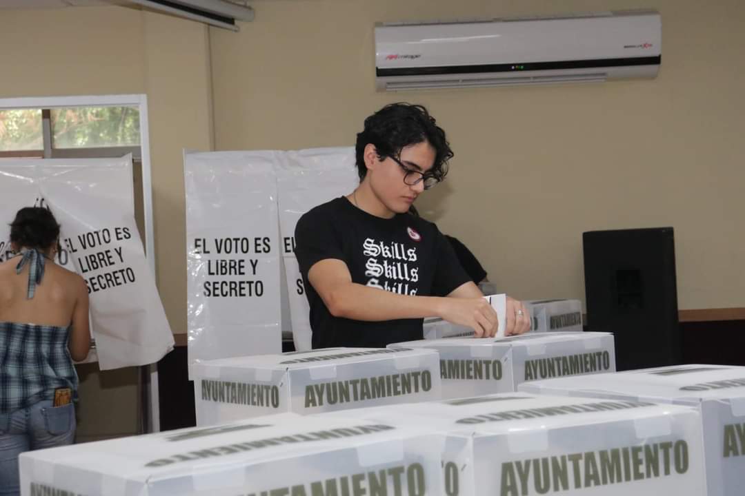 Joven estudiante en las urnas durante las elecciones de la UAdeO