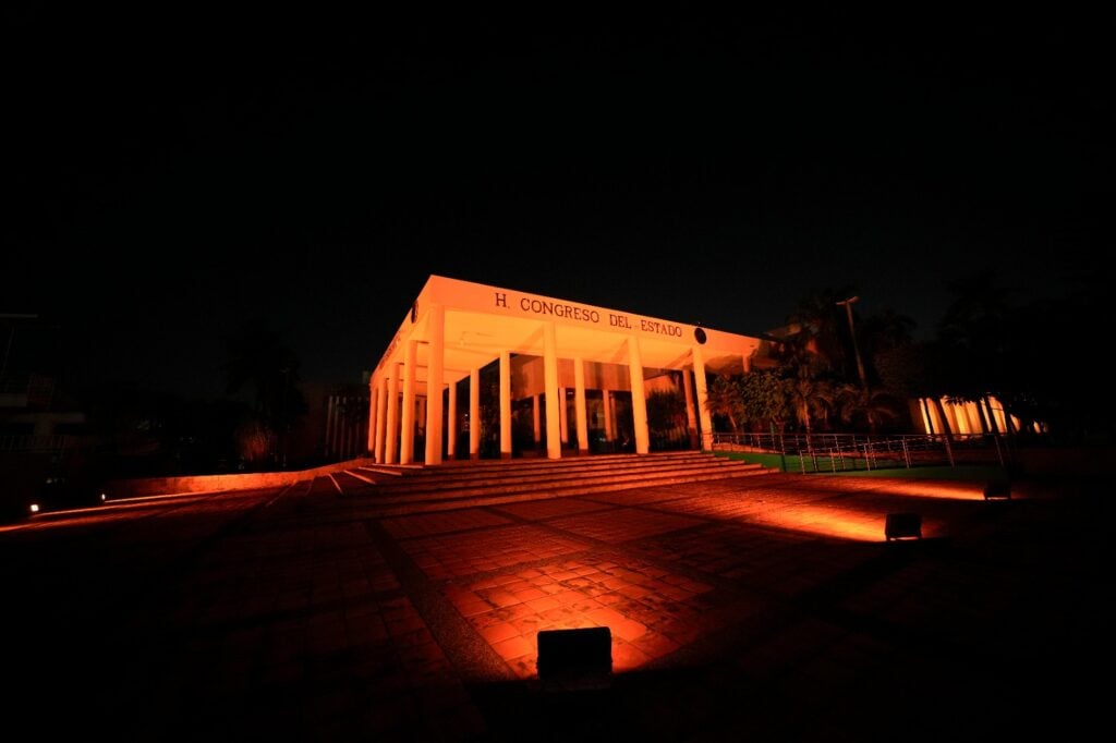 Congreso del Estado iluminado con luces doradas.