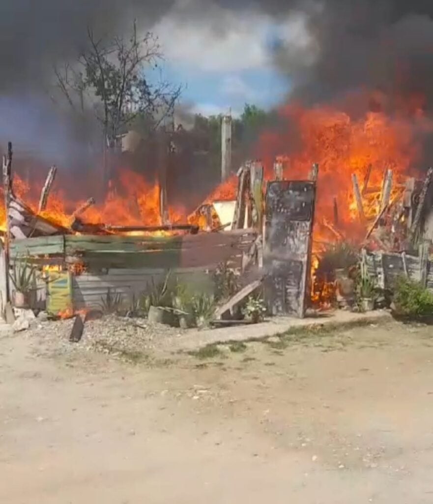 Vivienda de lámina y madera incendiándose.