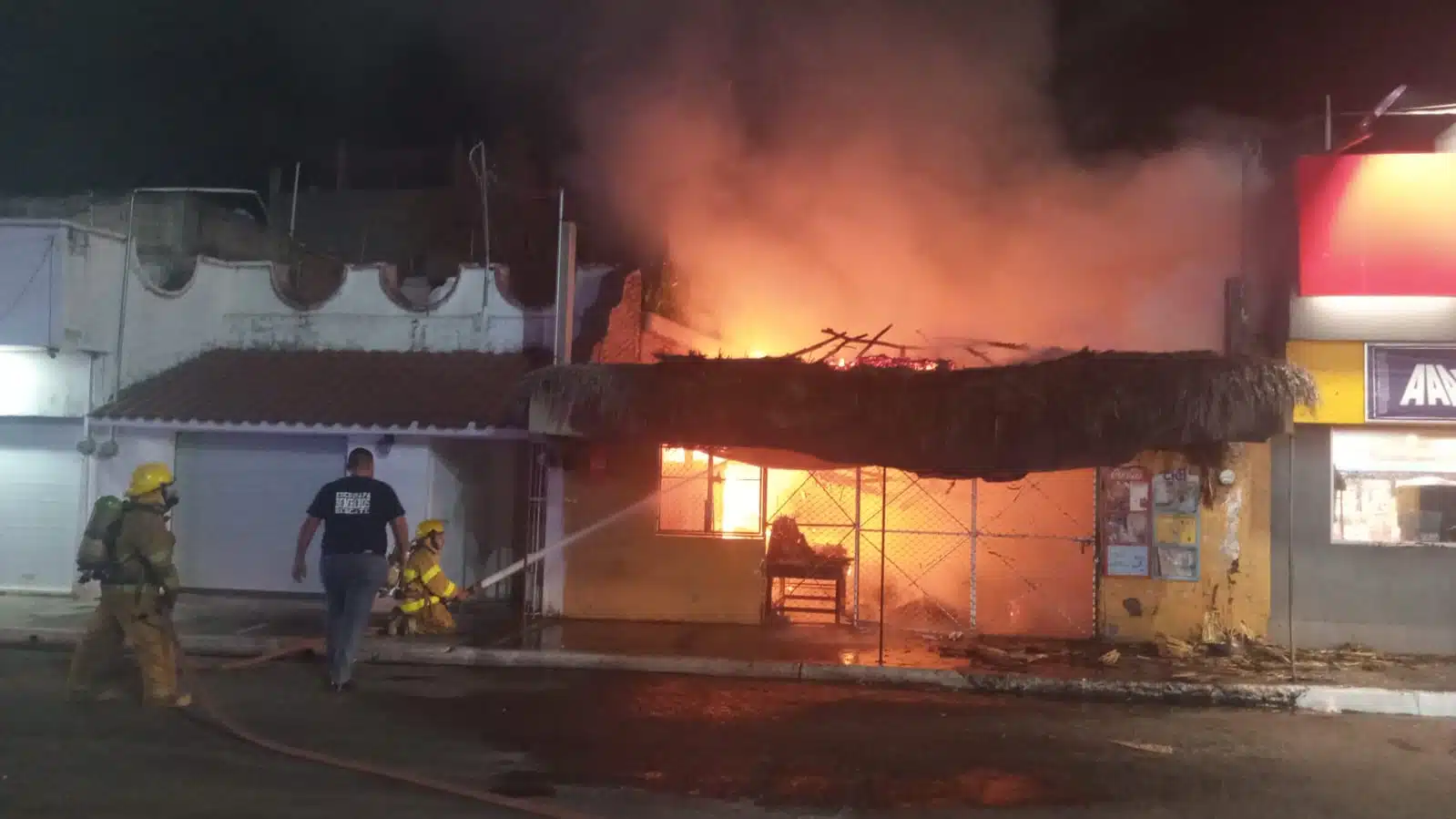 Bomberos de Escuinapa combatiendo el incendio de la frutería.