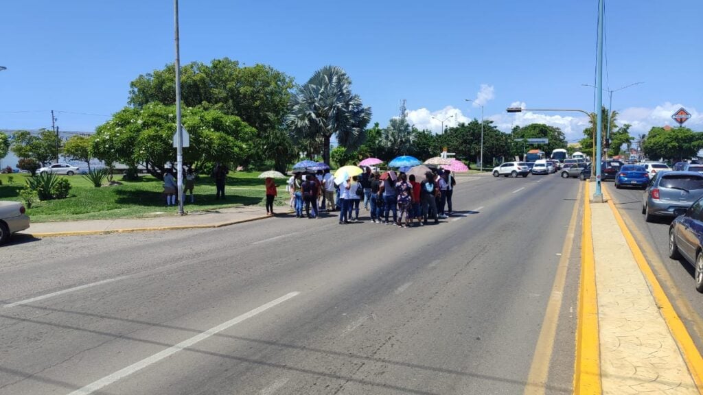 Personal docente y alumnos del telebachillerato manifestándose en la carretera Internacional al norte.