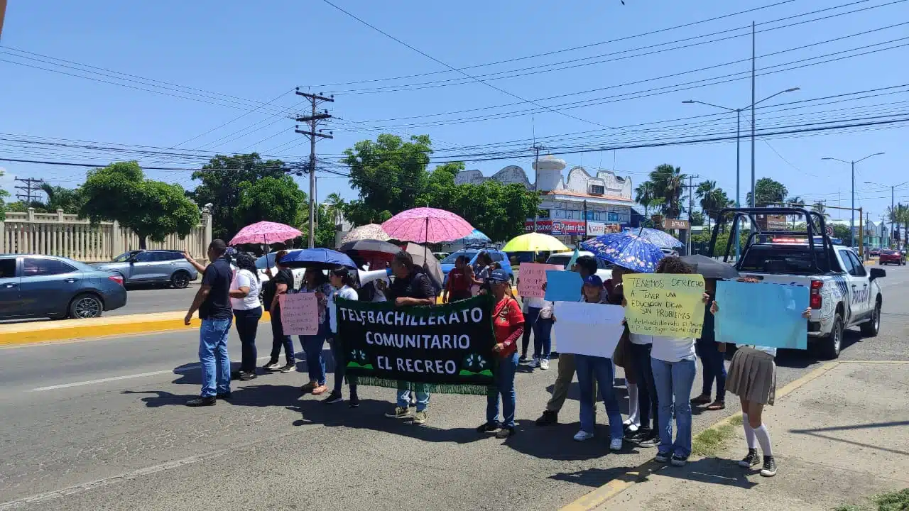 Personal docente y alumnos del telebachillerato manifestándose en la carretera Internacional al norte.