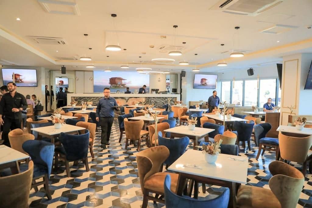 Imagen de un restaurante y meseros atendiendo a los clientes