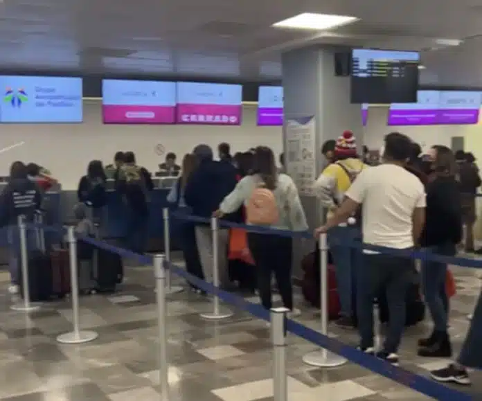 Una fila de personas en la terminal aérea de BCS