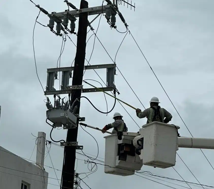 Trabajadores de la CFE restableciendo la energía eléctrica