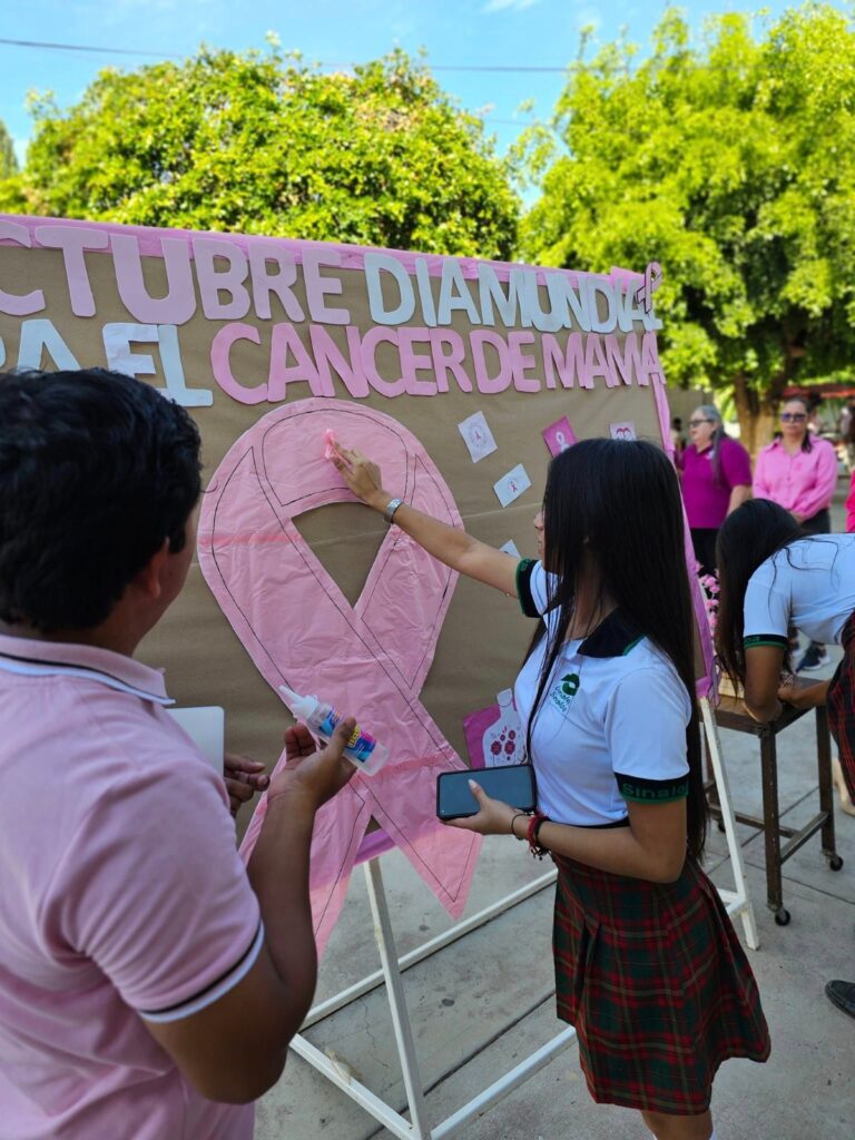 Alumnos de Conalep trabajando en una manualidad para informar acerca del cáncer de mama.