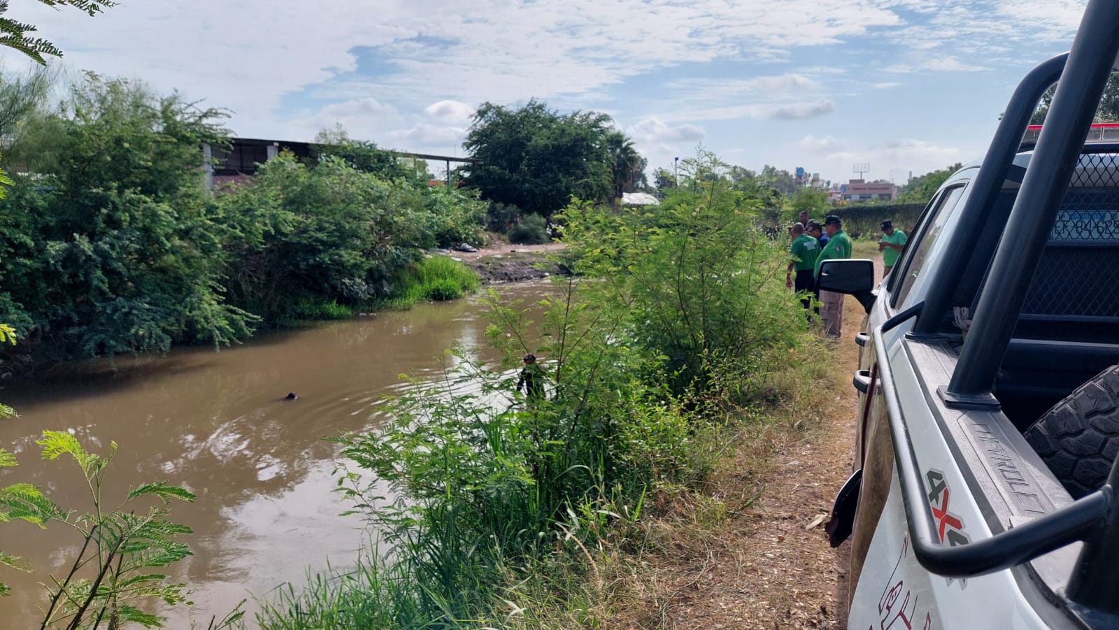 Una patrulla de la policía municipal de Ahome acude al lugar del reporte sobre una persona sin vida dentro de un canal de riego