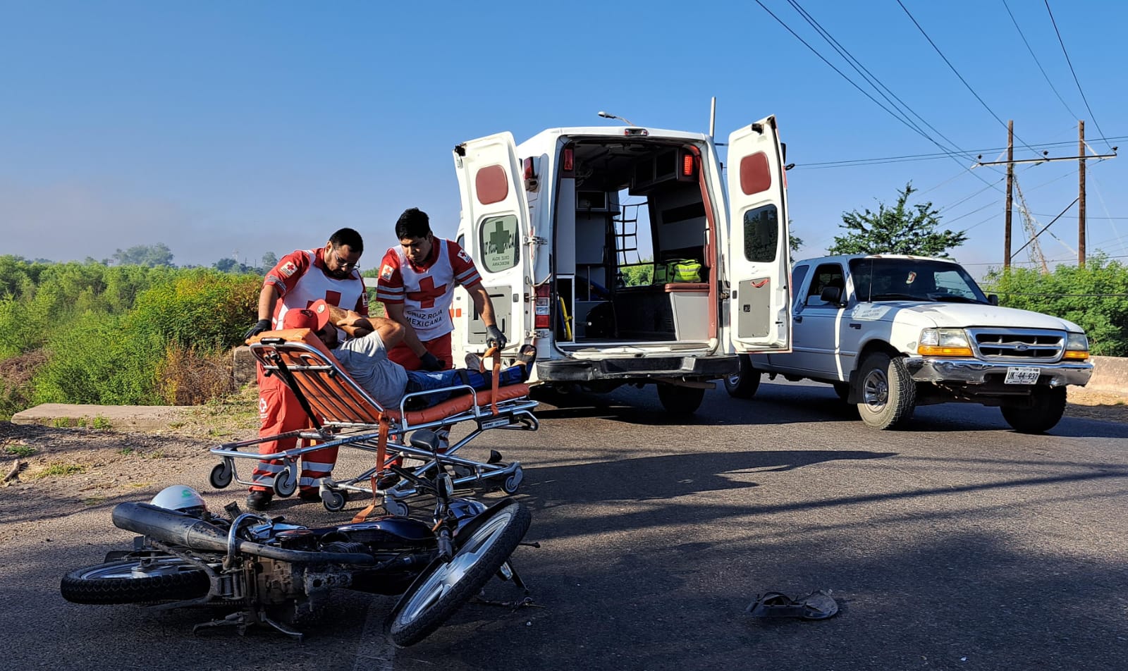 Paramédicos de Cruz Roja suben al motociclista lesionado a la ambulancia