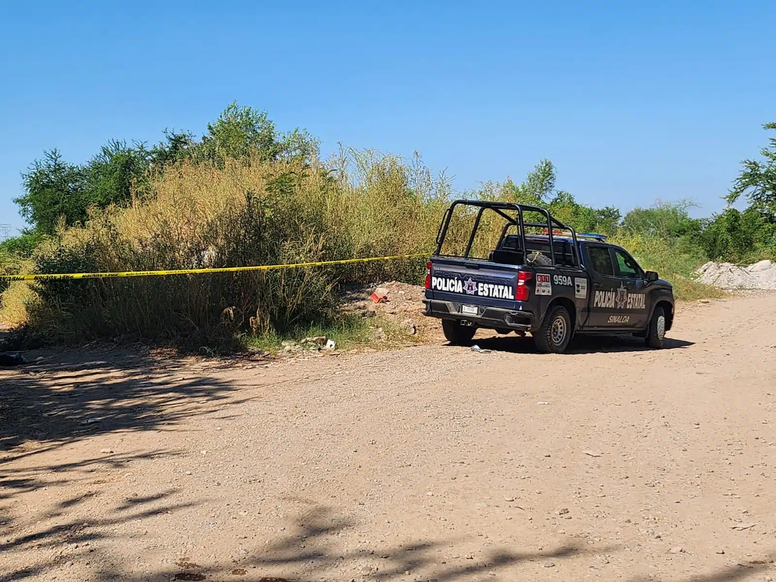 Patrulla de la Policía Estatal Preventiva en un terreno de terracería en Culiacán